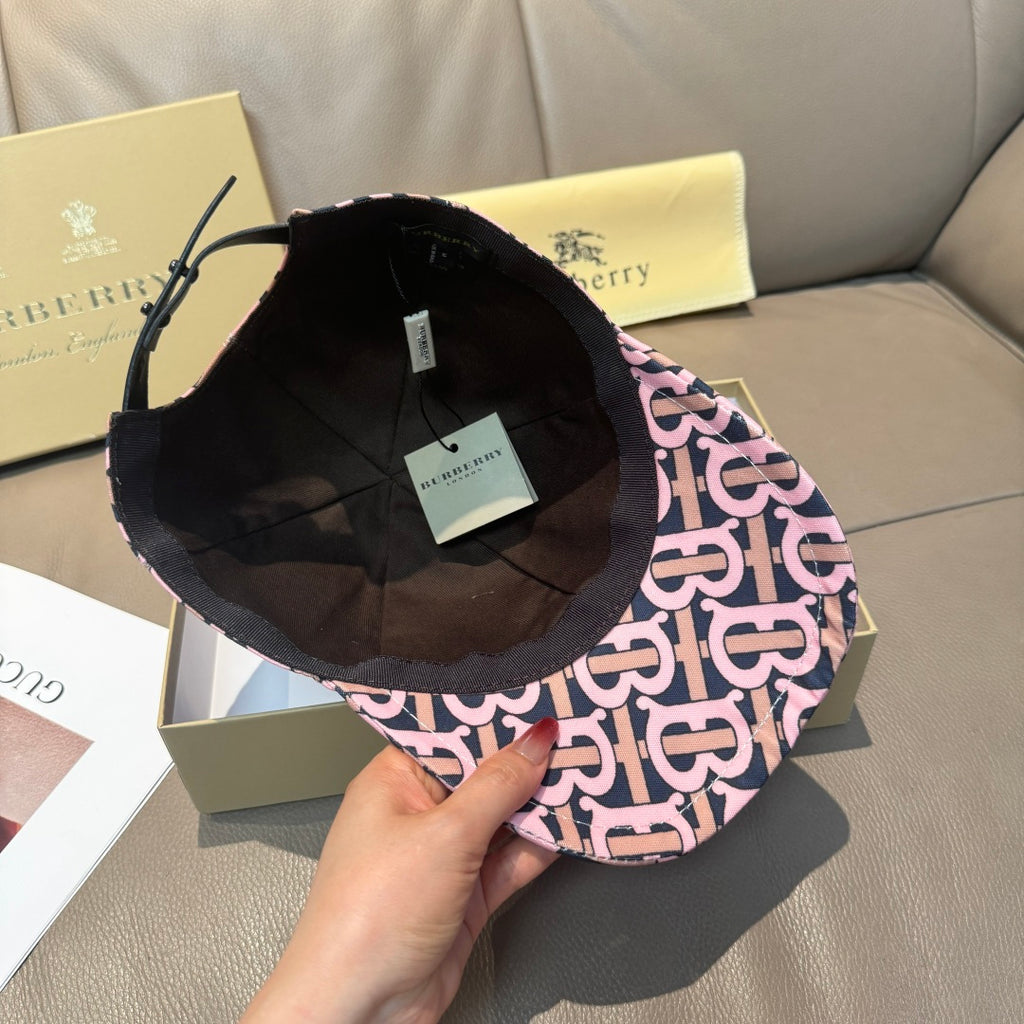 Burberry cap with pink and black monogram exterior and black interior lining, underside view
