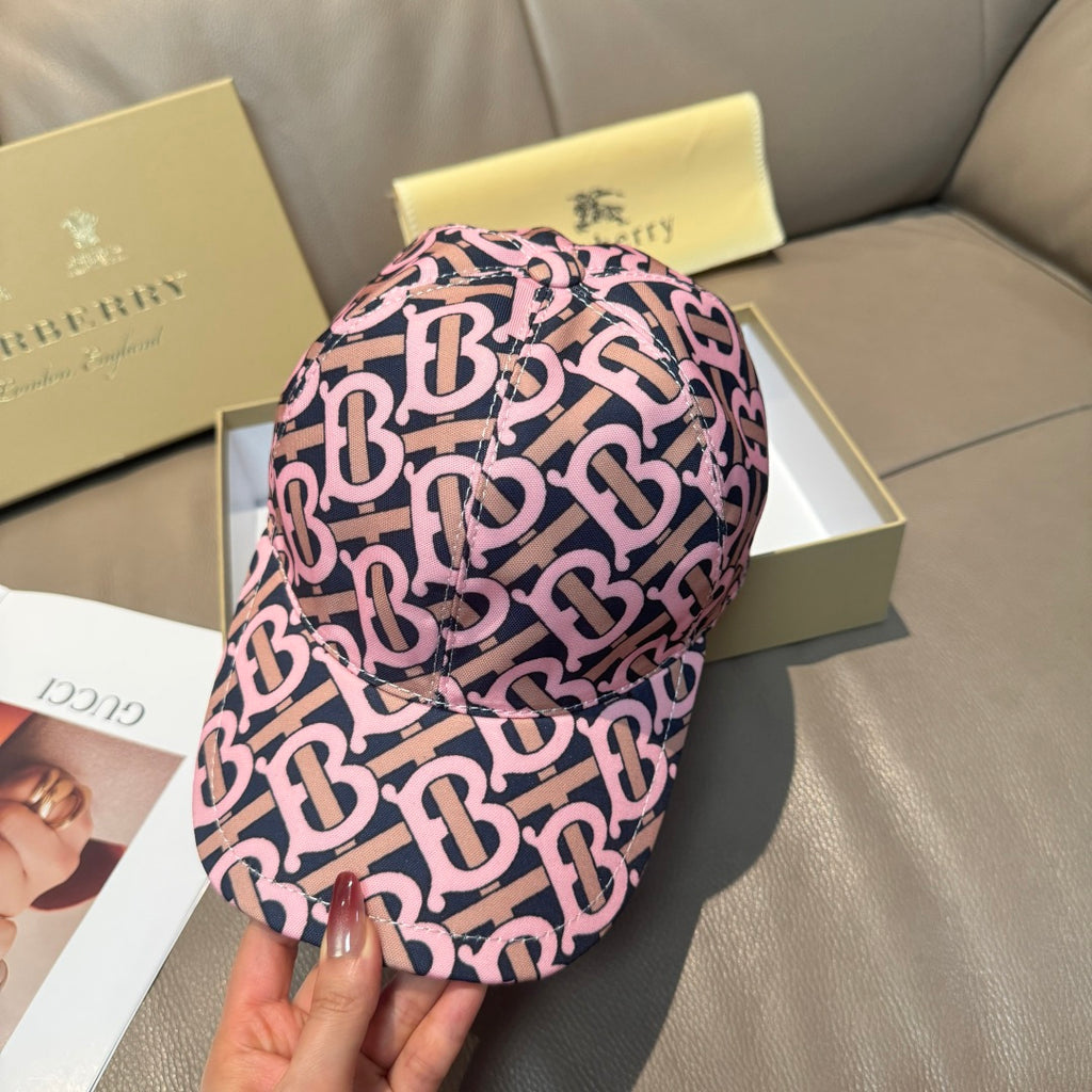 Burberry cap with pink and black monogram pattern, shown from side with brim and crown