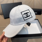 White baseball cap with Chanel CC logo patch and curved brim