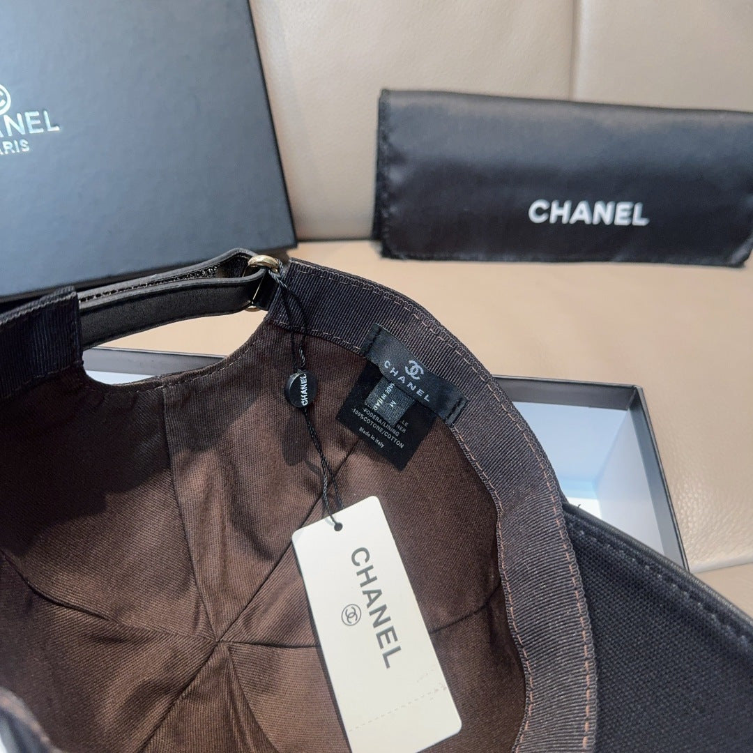Black Chanel cap with adjustable strap and hanging retail tags