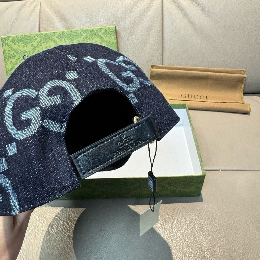 Gucci cap in dark navy denim with light blue GG pattern, black leather strap label.