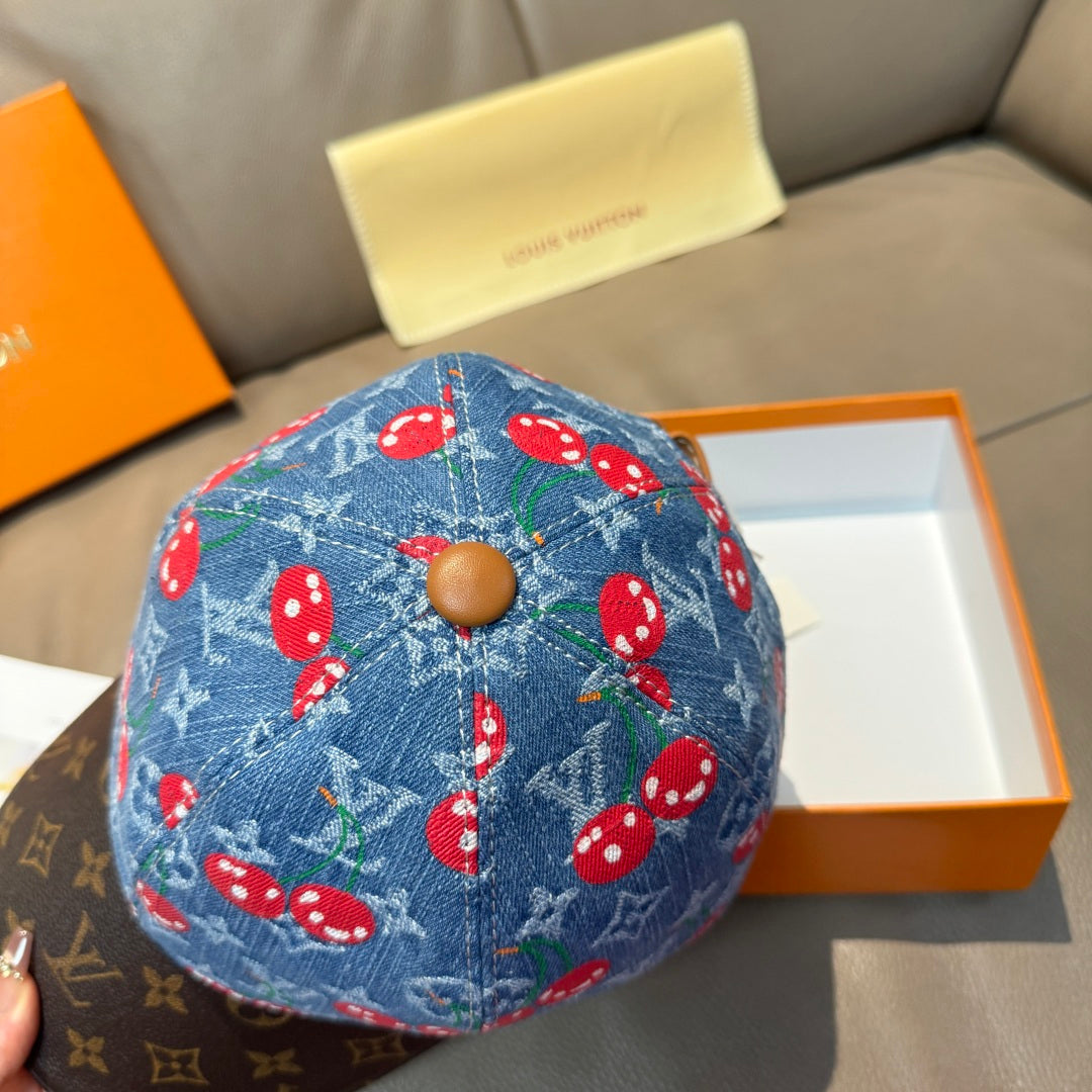 Louis Vuitton cap top view: blue denim with red mushrooms, tan button detail.