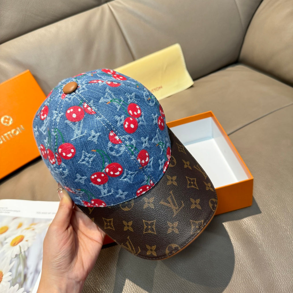 Louis Vuitton cap on hand: blue denim crown with red mushrooms, dark monogram brim.