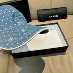 Blue denim cap brim with white dot and Chanel-style logo pattern, showing underside edge