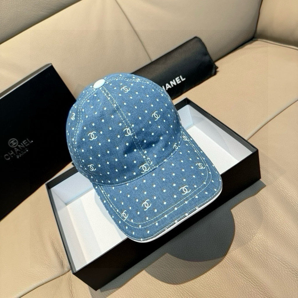Blue denim cap with white dot pattern and Chanel-style logo accents, worn over box