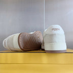 Cream low-top sneakers showing outsole tread and FENDI logo on heel tab