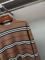 Close-up of brown crew-neck knit sweater with black-and-white stripe bands