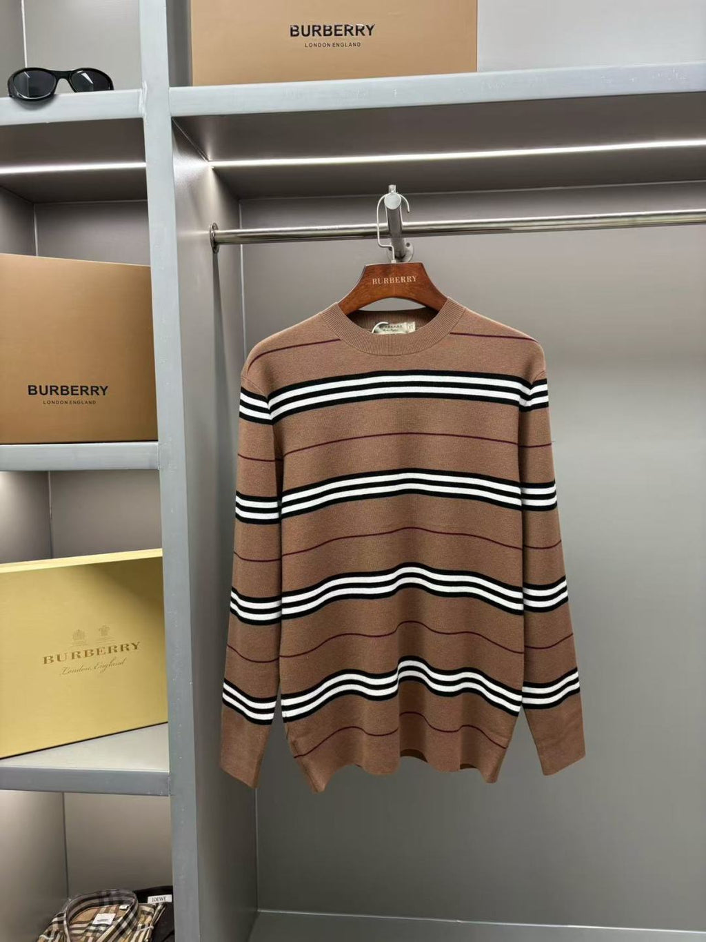 Brown striped knit sweater with crew neck and black-and-white wavy stripes