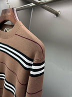 Brown knit sweater with black-and-white striped sleeve band and crew neck