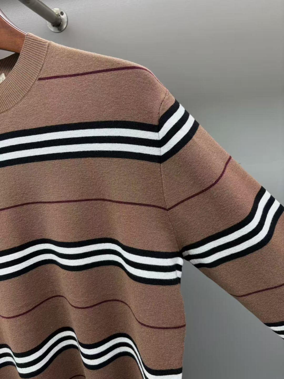 Close-up of brown knit sweater with black-and-white wavy stripe pattern