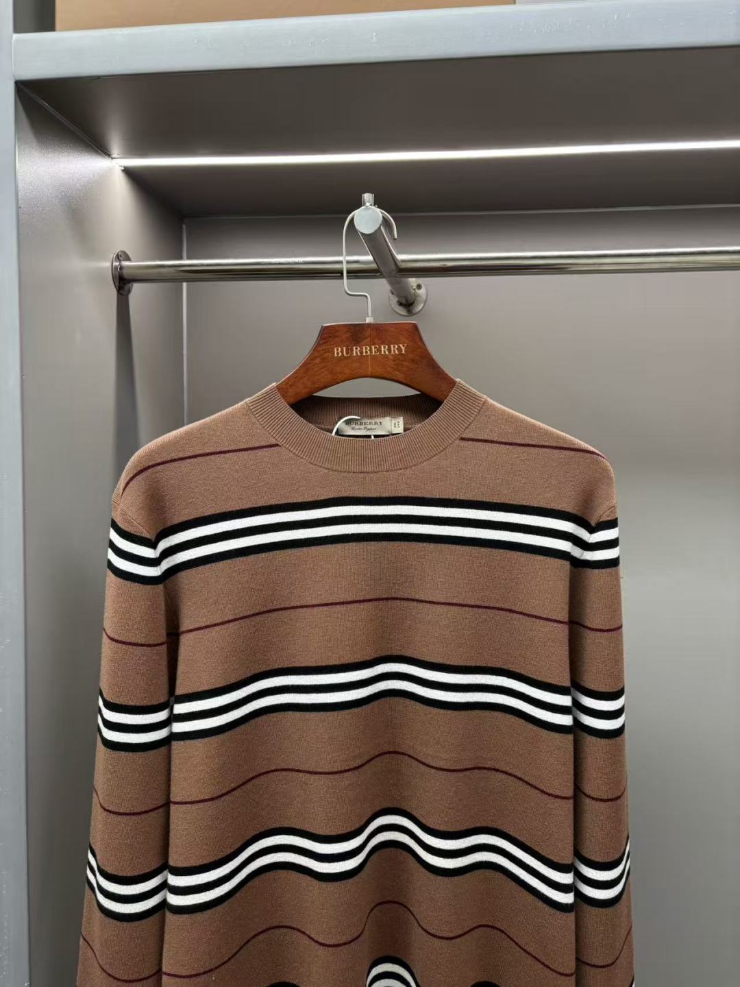 Brown crew-neck knit sweater with horizontal black-and-white stripe bands