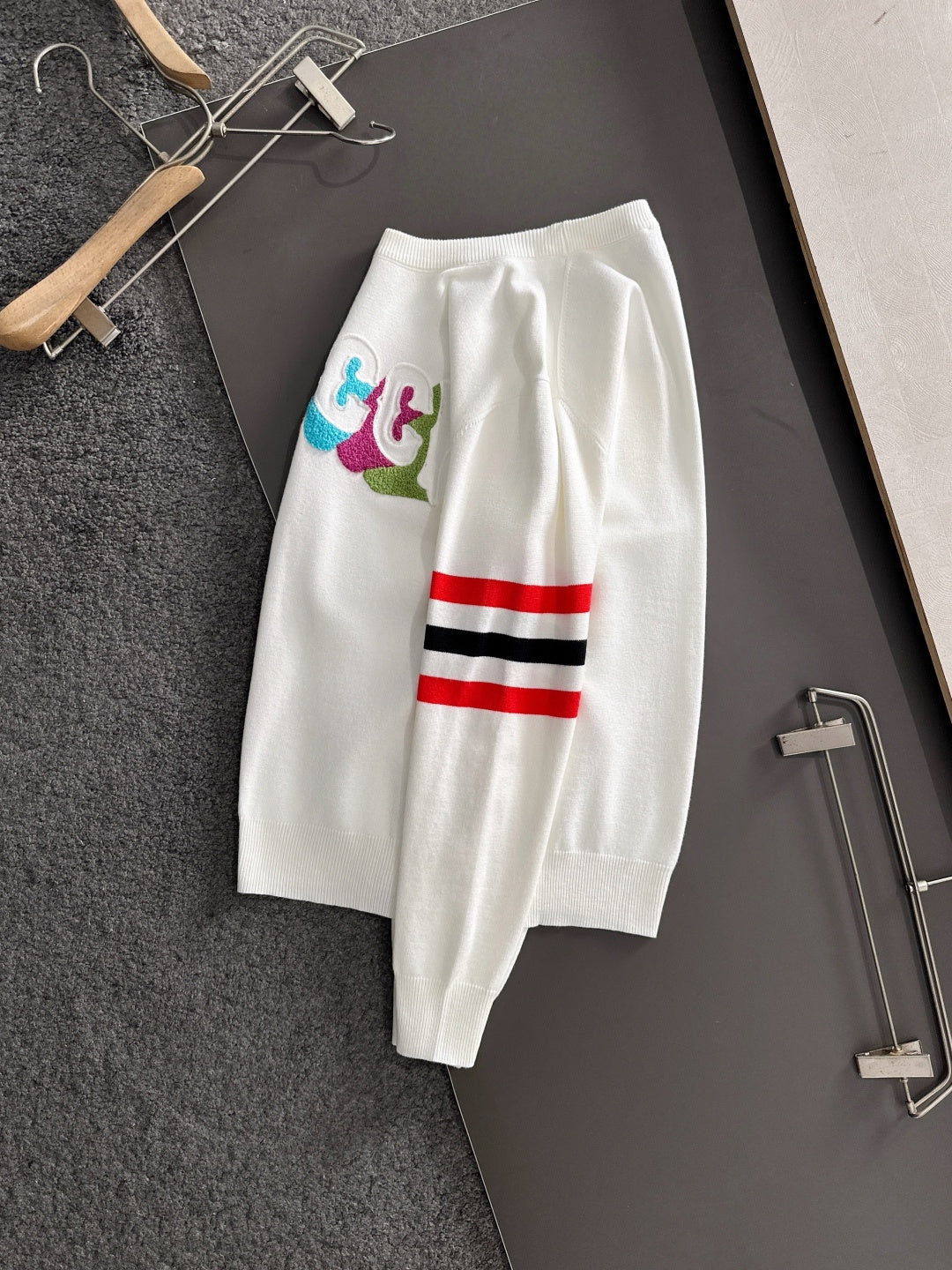White long pants with multicolor logo patch and red/black/white stripe detail