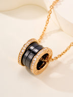 Bvlgari necklace pendant with gold ring and black enamel band, framed by crystal accents