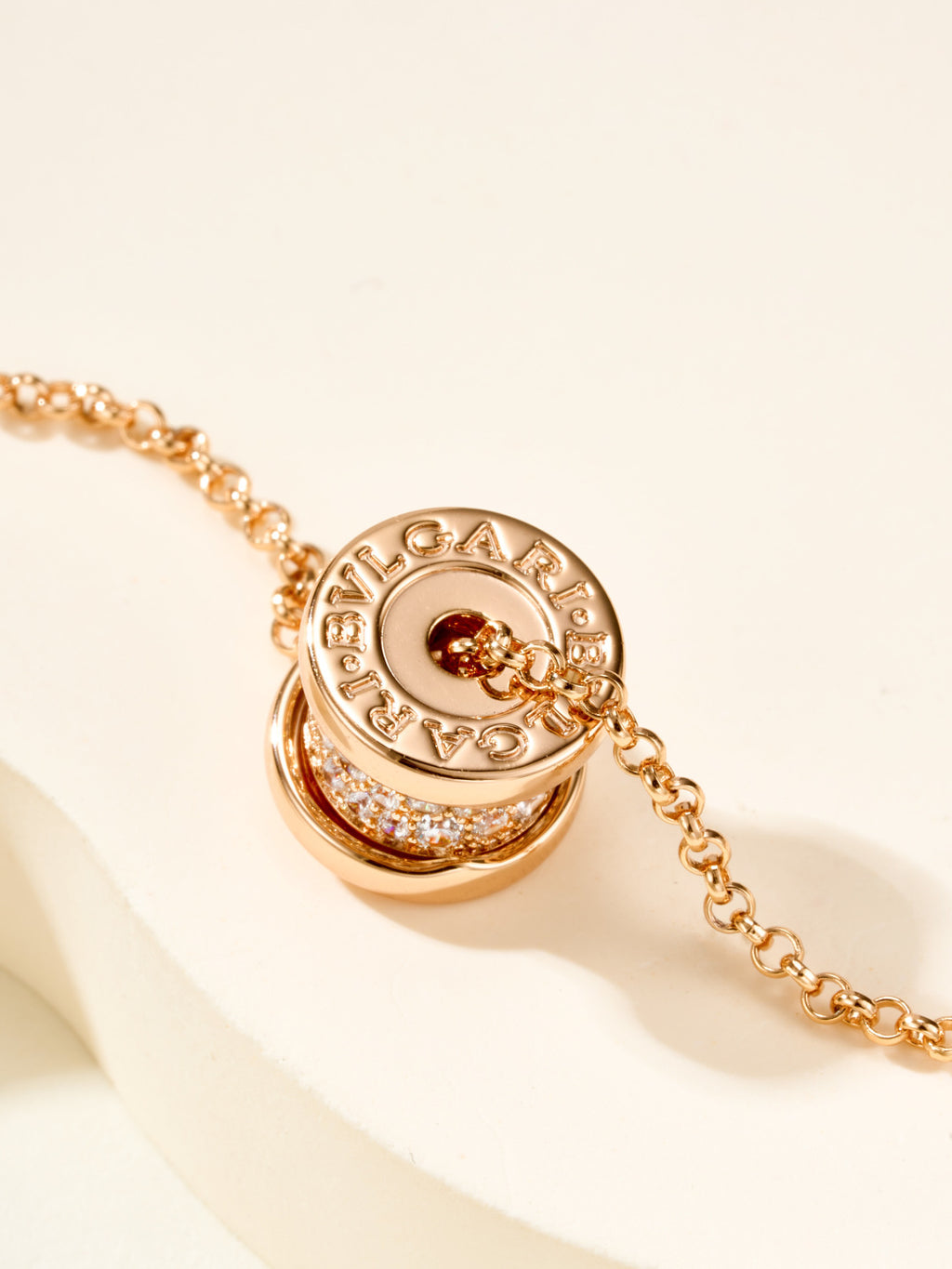 Gold necklace with Bvlgari logo coin charm and pavé border link chain
