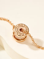 Gold necklace with Bvlgari logo coin charm and pavé border link chain