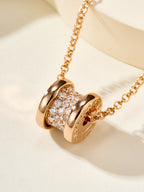 Gold necklace with pavé cylinder charm centerpiece on linked chain