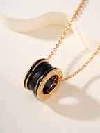 Gold-tone necklace with round black-and-gold pendant featuring engraved Bvlgari detail