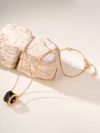 Gold-tone necklace with black enamel round pendant on a fine chain