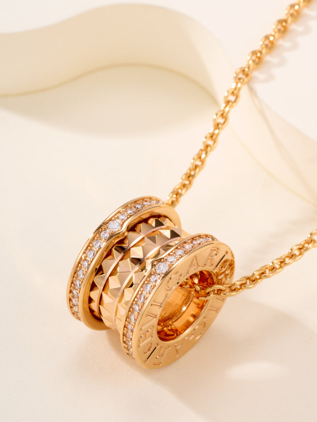Gold-tone necklace with ornate hoop pendant and orange gemstone center