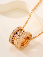 Gold-tone necklace with ornate hoop pendant and orange gemstone center