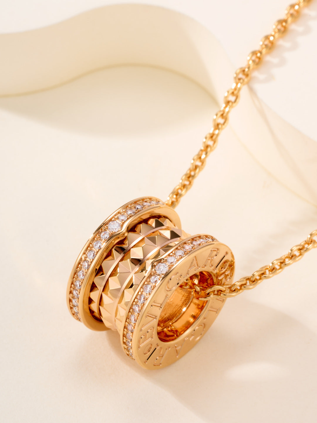 Gold-tone necklace with ornate hoop pendant and orange gemstone center