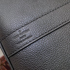 Louis Vuitton men’s dark blue leather bag close-up of embossed logo on leather