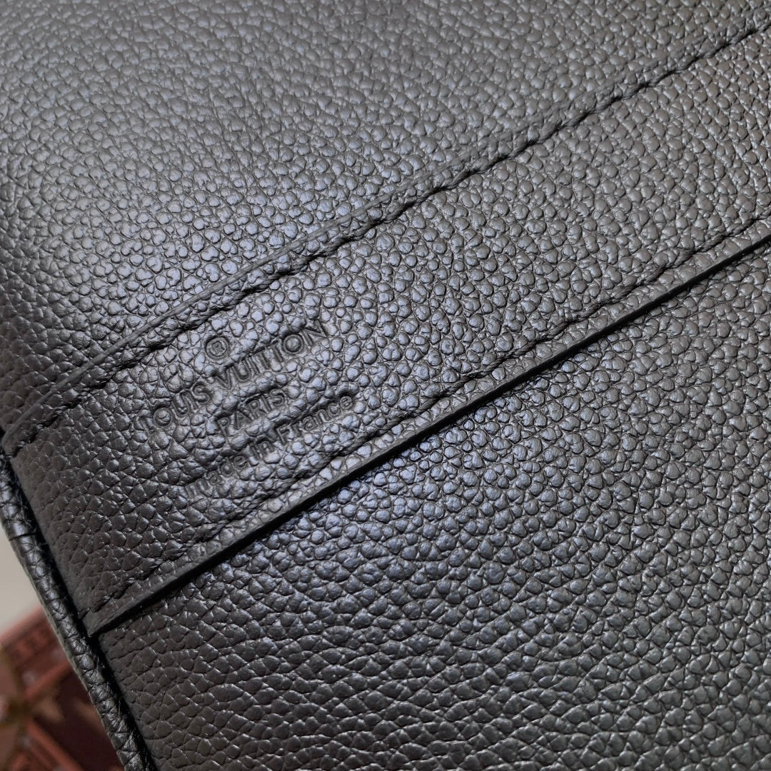 Louis Vuitton men’s dark blue leather bag close-up of embossed logo on leather