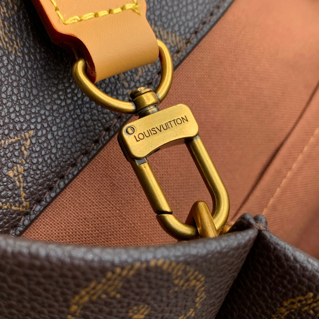 Louis Vuitton monogram bag clasp with tan leather tab and gold-tone hardware