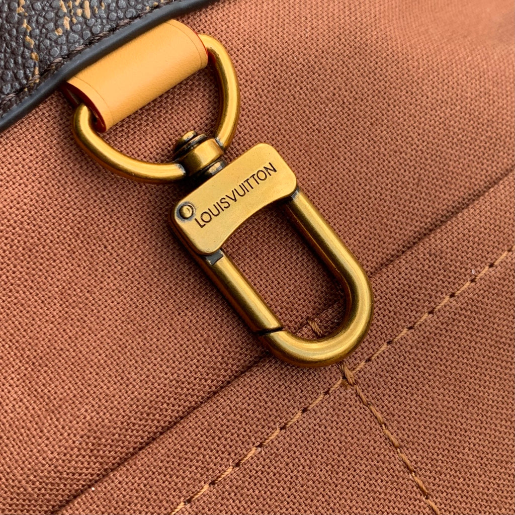 Louis Vuitton monogram bag D-ring hardware with tan leather handle attachment