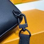Louis Vuitton bag in dark blue grained leather, close-up of D-ring and lock detail.