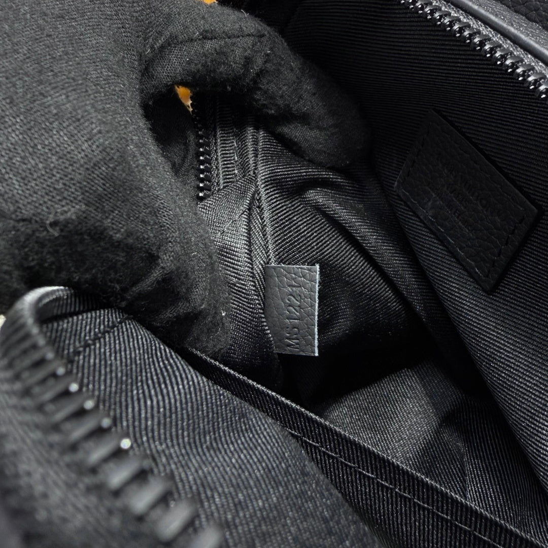 Black fabric pouch interior close-up with zipper track and fabric brand tag