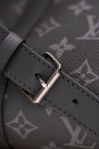 Leather strap with metal buckle on dark monogram canvas handbag