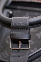 Adjustable leather shoulder strap with buckle and stitched monogram trim