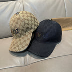 Pair of baseball caps: tan GG monogram and dark GG logo, curved brims.