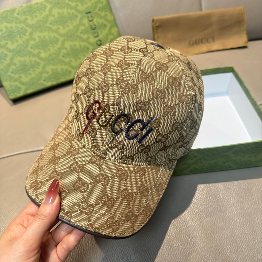 Tan GG monogram cap with embroidered “GUCCI” lettering and curved brim.