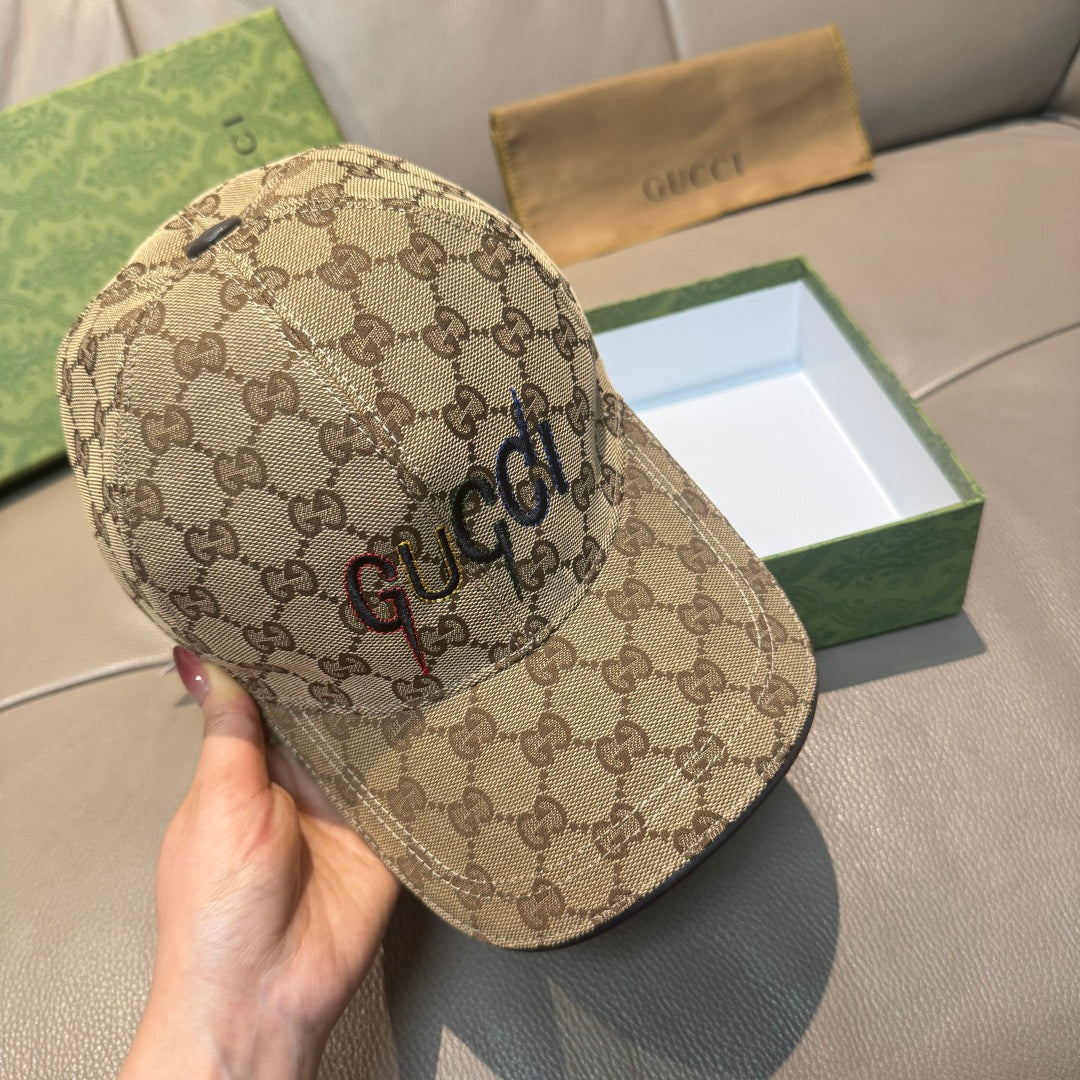 Brown GG monogram baseball cap with curved brim, held by hand at front.