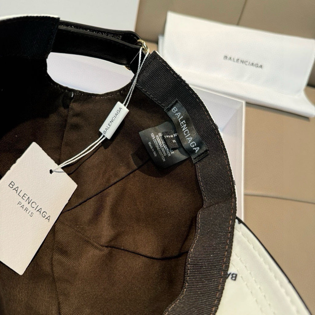 Balenciaga logo cap detail: white crown with black adjustable strap and tags