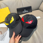 Two Fendi caps: one black with yellow graphic, one black with red graphic