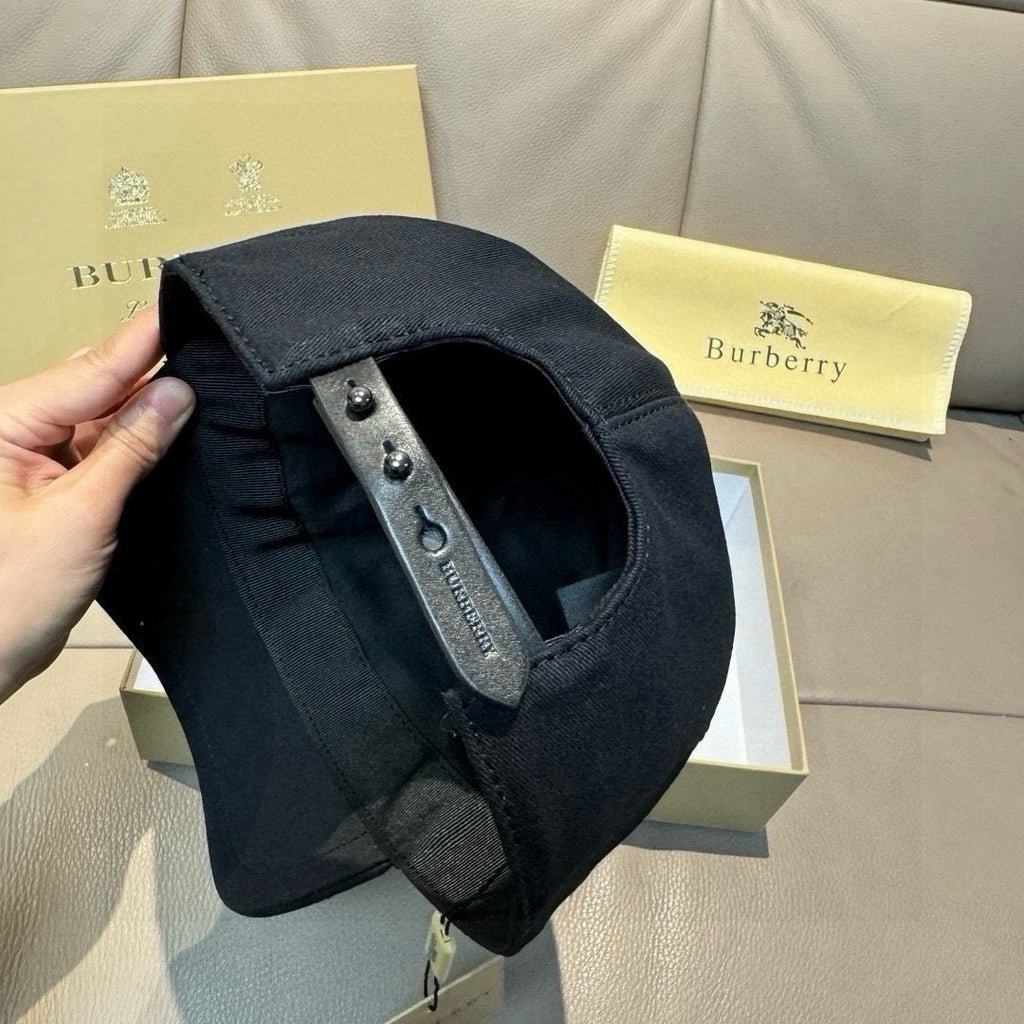 Dark cap side view with adjustable strap, metal eyelets, and interior lining