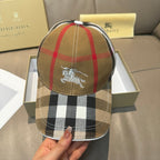 Burberry cap with front horse emblem on tan plaid crown.