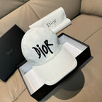 White Dior cap with black 'Dior' logo, curved brim, adjustable strap.