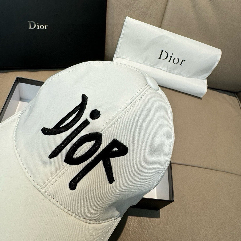 White Dior cap with large black 'Dior' logo on front, curved brim.