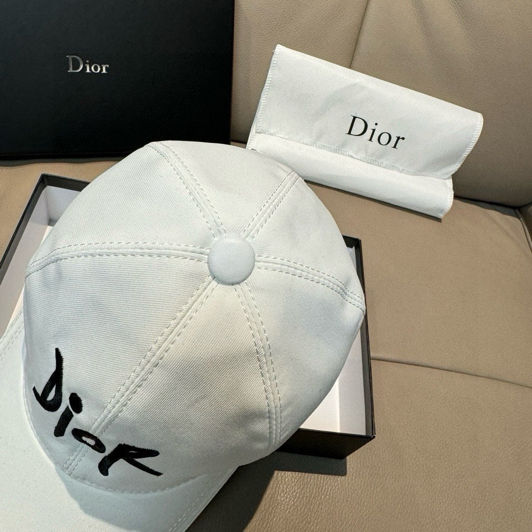 White Dior cap with small black 'Dior' signature, circular top button and stitching.