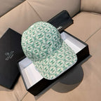 Chanel cap, mint green with repeating CC logo pattern, curved brim, buttoned crown.