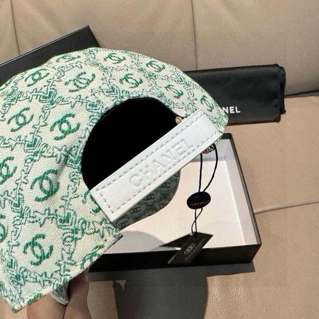 Chanel cap detail, mint green CC logo brim with white embroidered 'CHANEL' strap.