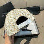 Beige gold monogram baseball cap with adjustable strap detail across the back.