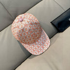 Peach-orange logo baseball cap with pink button, side view and curved brim