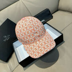 Orange logo baseball cap with pink button detail, curved brim and fabric pattern
