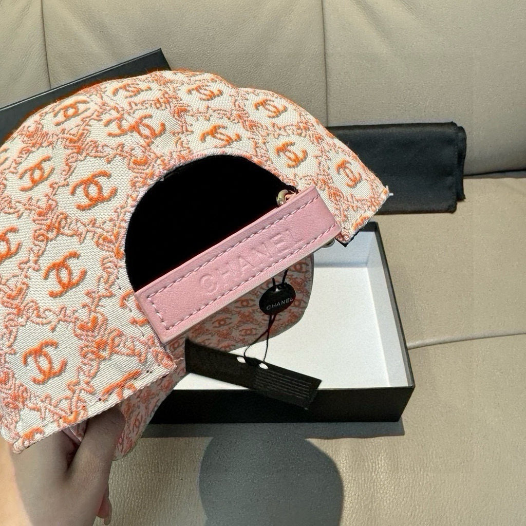Peach-orange logo baseball cap with pink strap, open interior and black lining