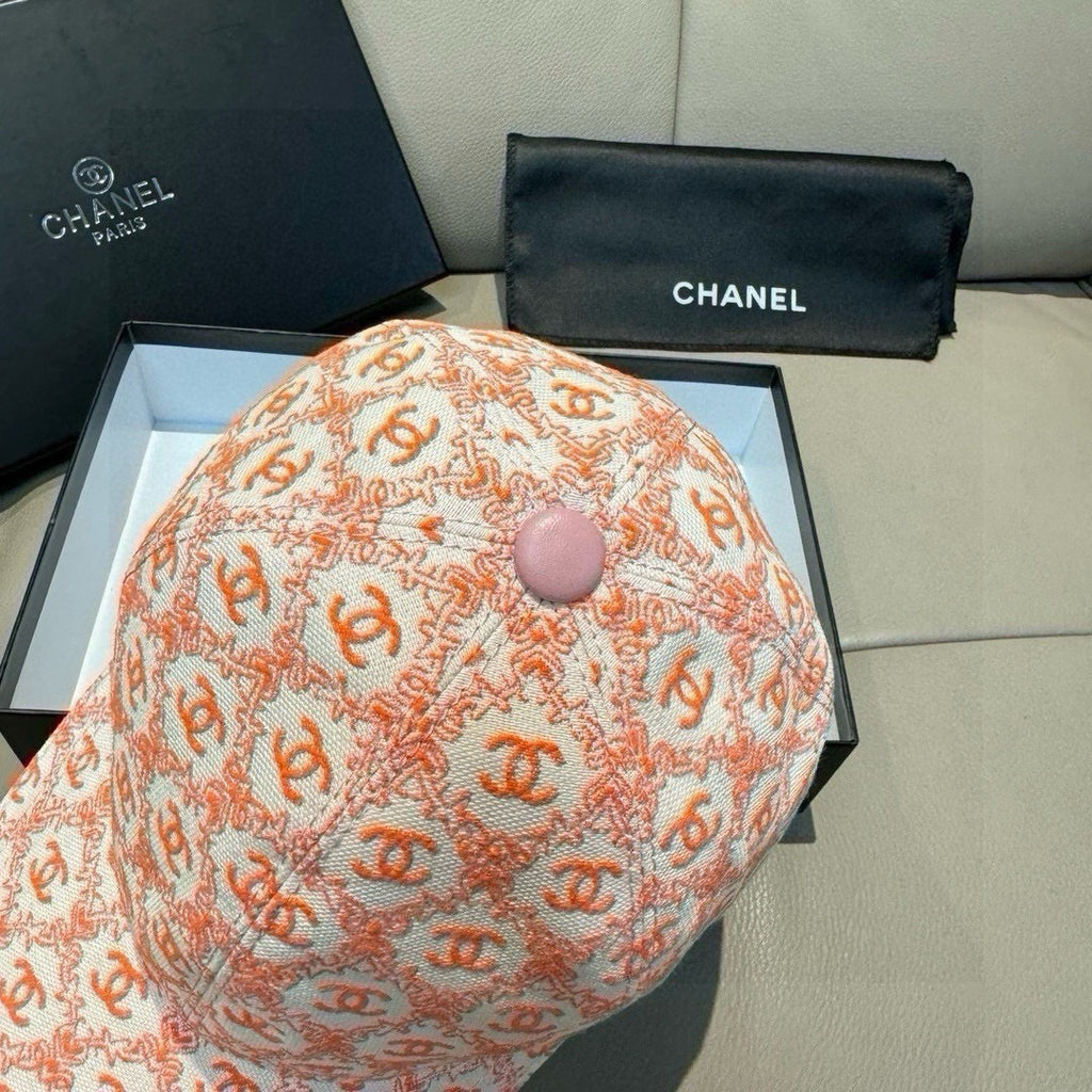 Peach-orange logo baseball cap top with round pink button and allover pattern